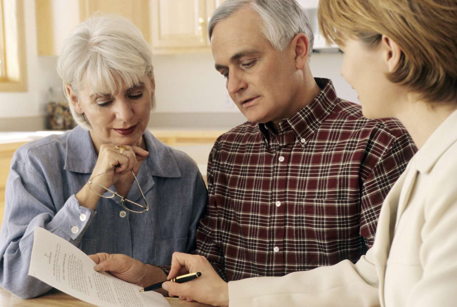 three people signing a document